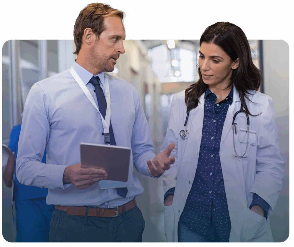 Two healthcare walkers in a hallway looking at an ipad