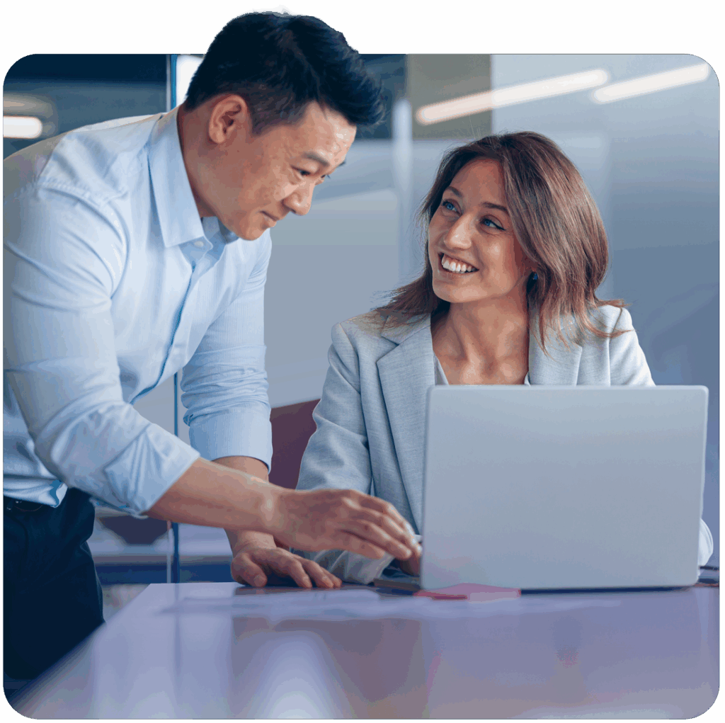 Man and woman talking while looking at a laptop