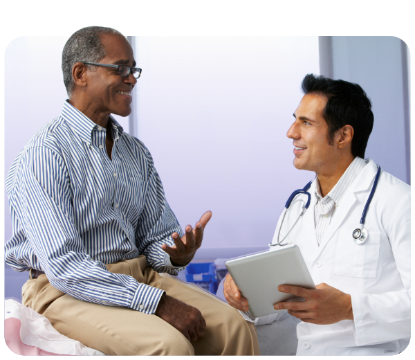 Male patient on exam table talking to clinician who is holding a tablet