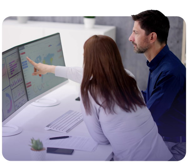 Woman and man looking at dual screen monitor