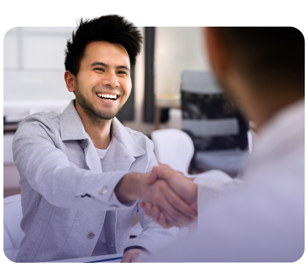 Smiling man shaking hands with someone in meeting room