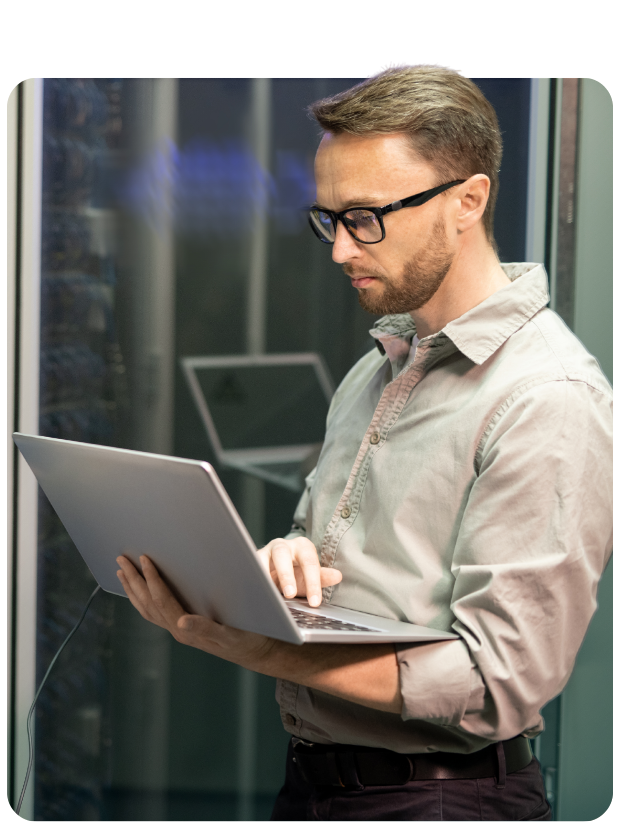 Man holding laptop in data center