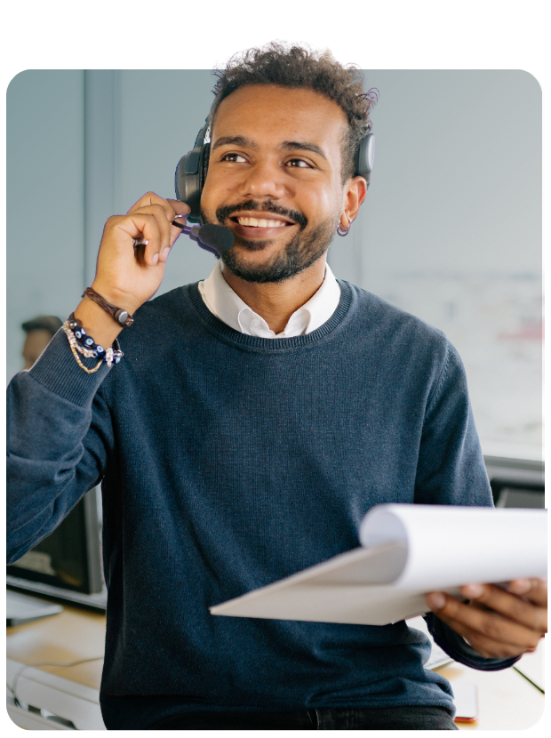 Man with headset and notepad smiling