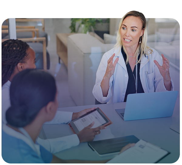 Female clinician describes something to colleagues using her hands with her laptop in front of her