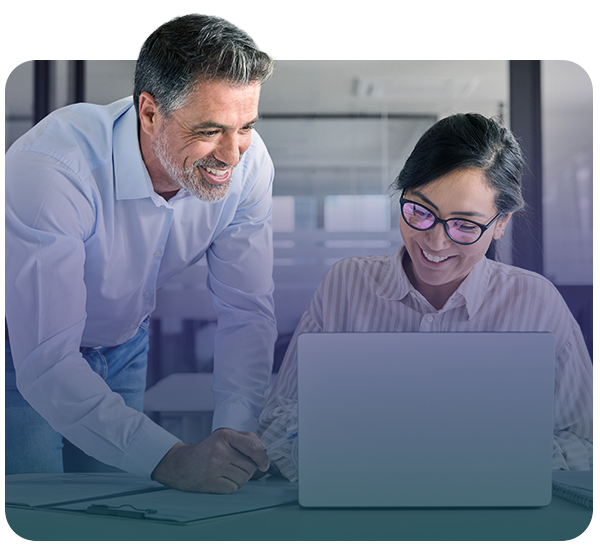 Man and woman smiling while looking at laptop