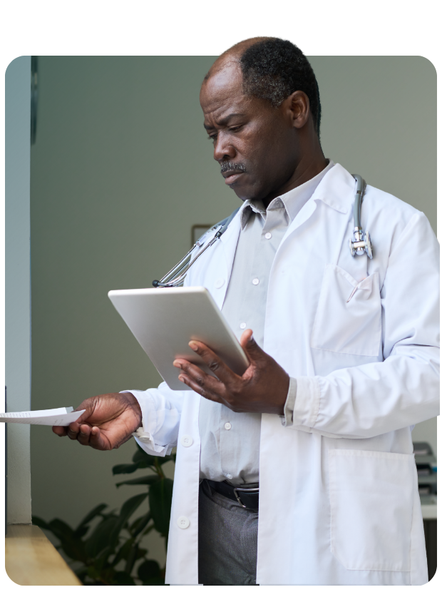 Concerned looking male clinician with tablet looking at paper