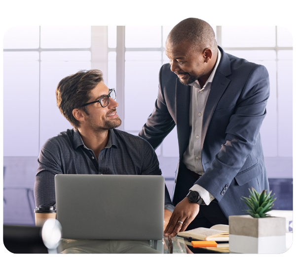 Business professionals smiling while using laptop