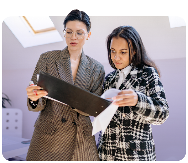 Two females review paperwork on clipboard